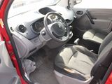 the interior of a small red car with the door open