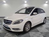 the white mercedes b - class is parked on a checkered floor