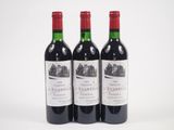 trois bouteilles de vin rouge posées l'une à côté de l'autre sur une surface blanche