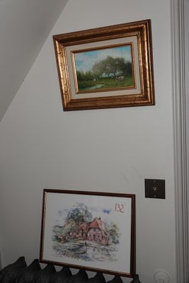 une photo d'un tableau accroché au mur au-dessus d'un lit