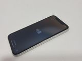 the back of a black and silver cell phone sitting on a table