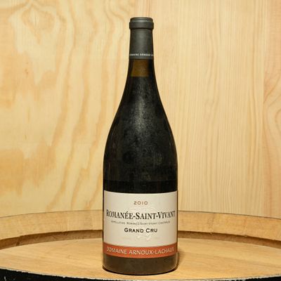 a bottle of wine sitting on top of a wooden barrel