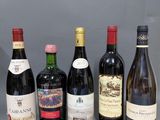 six bouteilles de vin sont alignées sur une surface grise
