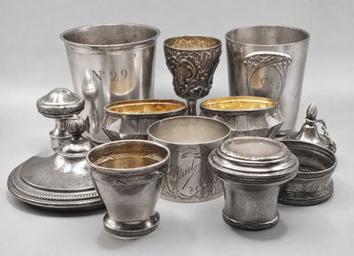several silver cups and saucers are arranged on a table