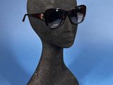 pair of sunglasses on a mannequin head on a blue background