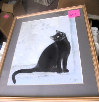 a picture of a black cat sitting in a picture frame