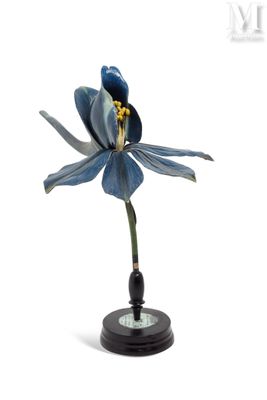 statue représentant une fleur bleue posée sur un socle noir, sur fond blanc