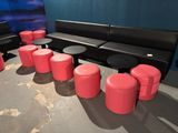 de nombreux tabourets et tables rouges dans un coin de la pièce