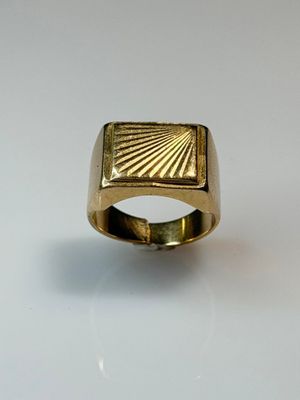 a close up of a gold ring on a white surface