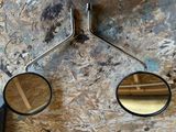 two mirrors hanging on the side of a wall