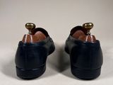 a pair of black shoes on a white surface