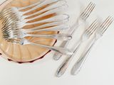 a lot of forks and spoons on a plate on the table