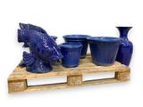 a wooden pallet with blue vases and a statue of a fish
