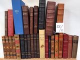 a lot of books that are stacked on a shelf