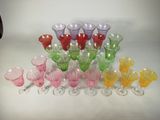 many different colored glasses sitting on a white surface