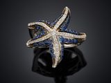 a close up of a starfish ring with blue and white diamonds