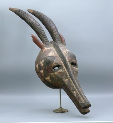 an image of a wooden mask with horns on a stand