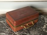 a small brown suitcase sitting on a marble table