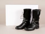 une paire de bottes noires posée sur une boîte blanche