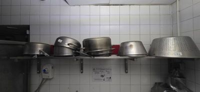 many pots and pans on a shelf in the kitchen