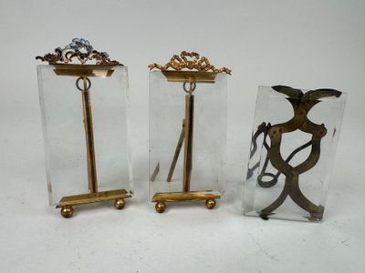 three pieces of glass and brass are sitting on a white surface