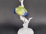 a figurine of a bird perched on a tree branch