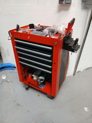 une boîte à outils rouge sur laquelle sont posés des outils, dans un garage