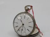a small silver pocket watch with a tag attached to it