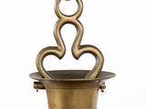 an image of a brass vase with two hearts hanging from it ' s side