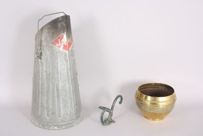 a silver pitcher and a gold cup next to each other