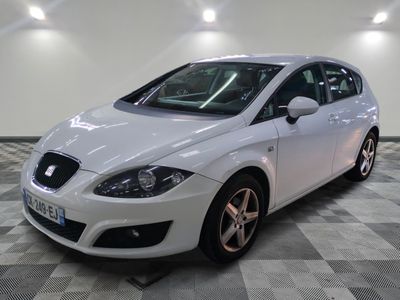 the white car is parked on the checkered floor in the room