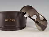 pair of gucci sunglasses with case on a white surface