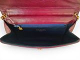 the inside of a red and black purse with a gold chain