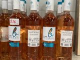 six bouteilles de vin rosé sont alignées sur une étagère