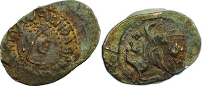 a close up of two ancient coins on a white surface