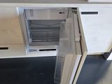 a small refrigerator that is open on the kitchen counter