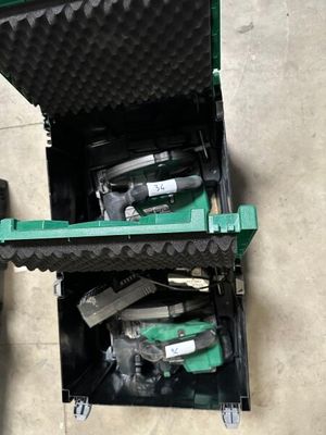 a green box with tools inside of it on the floor