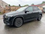 a black mercedes suv parked in a parking lot next to a building