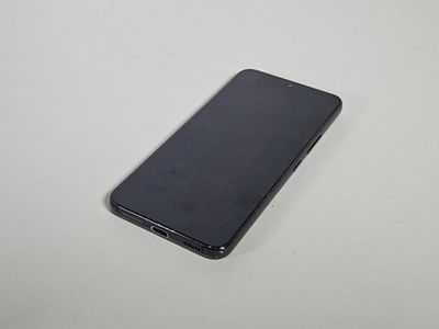 le dos d'un téléphone portable noir posé sur une table blanche