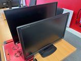 two monitors sitting on a desk next to each other