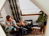 a picture of a man and a woman sitting on a couch in front of a mirror