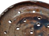 a rusted metal plate with holes in it
