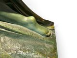 statue of a woman laying down on the ground with her feet on the ground