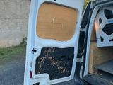 une camionnette blanche dont la portière et le hayon sont ouverts