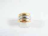 une image représentant une bague en or et en argent posée sur une surface blanche