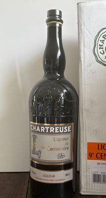 une bouteille d'alcool posée à côté d'une boîte sur une table