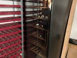 a wine cooler in the middle of a room with shelves