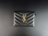 un petit portefeuille noir orné d'un logo YSL doré