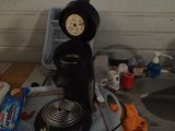 a black coffee maker on top of a kitchen counter