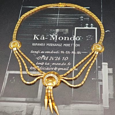 un collier en or exposé dans une vitrine
